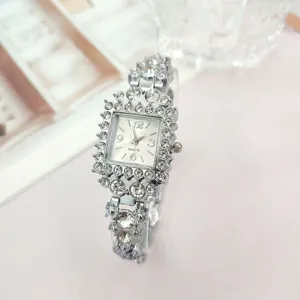 Dettaglio ravvicinato dell'orologio da polso quadrato in argento con strass e cinturino.