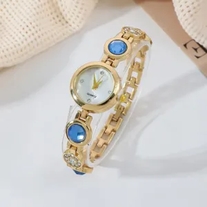 Luxus goldene Damen Quarzuhr mit blauen runden Steinakzenten und Diamantarmband.