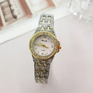 Closeup detail of a luxury women rhinestone quartz watch with silver gold metal strap.