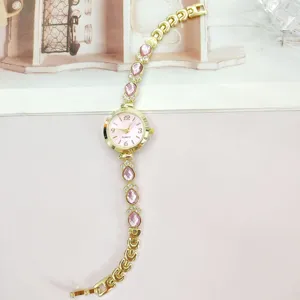 Luxus goldene Damen Quarz Uhr mit glänzenden rosa Tropfen Kristall Strass Armbändern.
