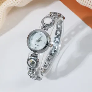 Nahaufnahme der silbernen Quarz-Armbanduhr mit glitzernden Strasssteinen und feinem Zifferblatt.