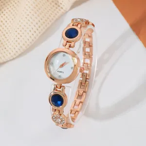 Detailansicht Damenuhr Quarz, Roségold Armband mit blauen Steinen und funkelnden Strass.