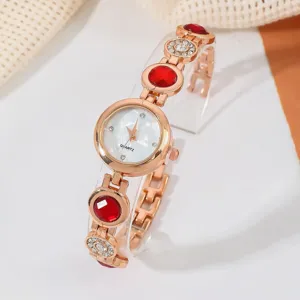 Elegante roségoldene Damenuhr Quarz mit roten Steinen und klarem Kunststoffständer.