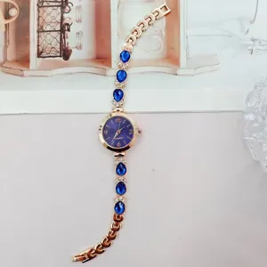 Detailaufnahme der Luxus Damen Quarzuhr mit blauen Tropfen Strasssteinen und Roségold Armband.