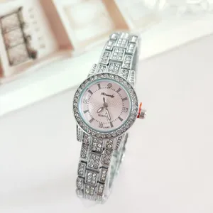 Detail view of a luxury rhinestone-studded quartz women's watch with pink dial and metal strap.