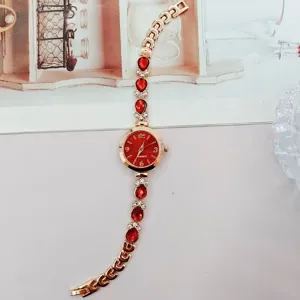 Detailansicht der goldenen Damen Quarz-Armbanduhr mit roten Edelstein-Dekor und feinem Armband.