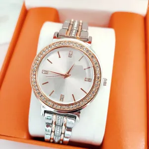 Detailed view of women quartz watch featuring rhinestone bezel and two tone metal strap.