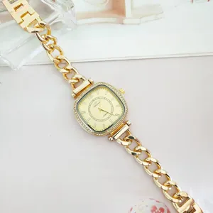 Primer plano detalle de reloj mujer oro cuadrado circón lujo pulsera cadena muy fina.