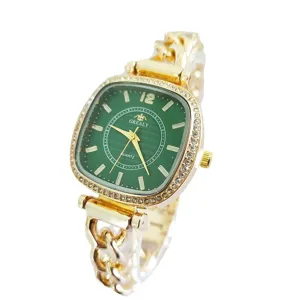 Vista detallada reloj cuarzo cuadrado mujer, esfera verde, correa cadena oro, estrás.