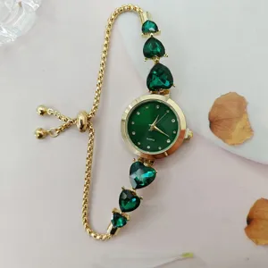 Exquisite Damenuhr Quhr mit grünen Herz Kristallen und verstellbarem Gold Ketten Armband.