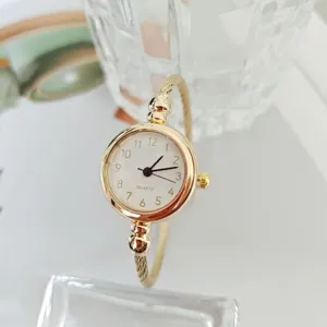 Reloj de cuarzo minimalista dorado con pulsera, elegante accesorio de moda detalle.