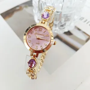 Detailed view of the luxury women quartz bracelet watch with pink dial and purple stones.