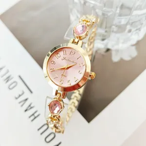 Close-up view of gold-tone quartz watch with pink dial and sparkling pink gemstone bracelet.