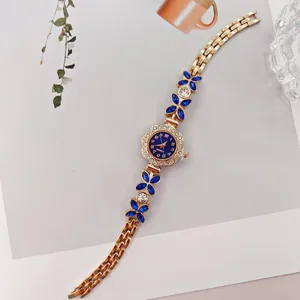 Elegante Damen Quarzarmbanduhr mit blauen Kristallblüten und goldenem Gliederarmband.