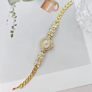 Goldene Damen Quarzuhr mit glitzerndem Strass Blumen Armband Design fuer elegante Anlaesse.
