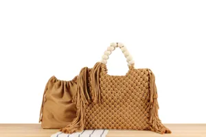 Nahaufnahme der handgemachten Makramee Handtasche aus Baumwolle mit Holzperlen und Fransen.