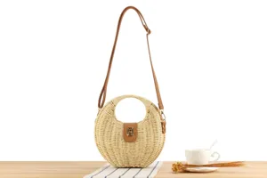 Handmade woven straw crossbody bag detail, round hollow handle, casual seaside vacation style.