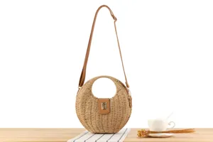 Handmade woven straw crossbody bag for women, stylish round design with shoulder strap and lock.