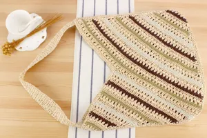 Handcrafted woven shoulder bag featuring diagonal colorful stripes, ideal for casual seaside vacation.