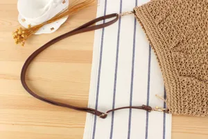 Détail de la sangle et de la texture en paille du sac à bandoulière tissé pour le quotidien.