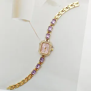 Primo piano dettagliato di un orologio al quarzo quadrato con strass e maglie in cristallo viola.