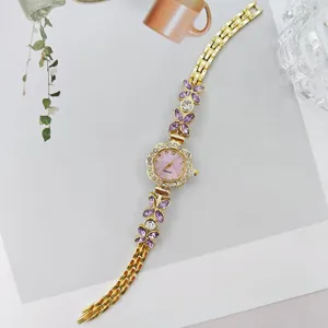 Elegante goldene Damen Quarzuhr mit rosafarbenem Zifferblatt und lila Kristallblumen.