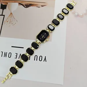 Goldfarbene Damen Quarzarmbanduhr mit schwarzen facettierten Edelstein-Armband chic.