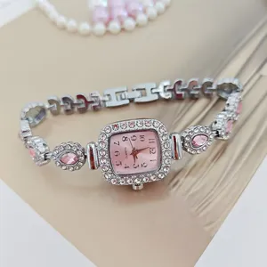 Elegante Damen Quarz Armbanduhr mit rosafarbenem Zifferblatt und funkelndem Strassbesatz.