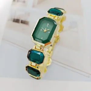 Elegante Damen Quarzuhr mit smaragdgrünem Kristall und goldenem Gliederarmband.