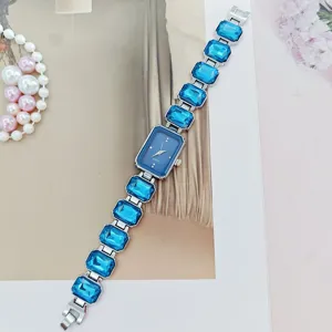 Detailed view of women blue crystal quartz watch featuring rectangular dial and gemstone bracelet.