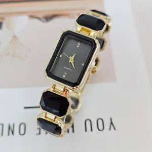 Close-up of women's quartz watch with black rectangular dial and gemstone bracelet.