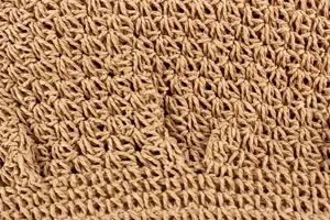 Sac à bandoulière en paille tissée main détail texture gros plan, style plage été.