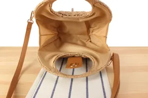 Detailed view of the handmade woven straw crossbody bag interior structure and brown lining.