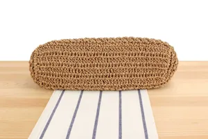 Gros plan detaille de la structure inferieure du sac a bandouliere en paille tisse.