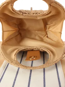 Handmade woven straw bag with round handles and spacious interior lining for summer beach vacation.