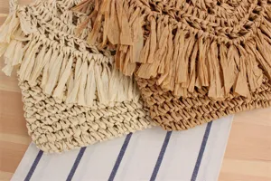 Woven fringe clutch detail, straw material bag close-up showing texture and craft.