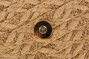 Close-up detail of women woven straw bag texture and metallic magnetic snap button design.