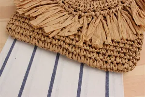Detailed view of the stylish woven straw flap bag with unique tassel fringe design.