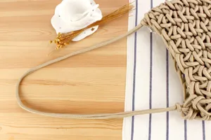 Handmade woven rope shoulder bag detail showing knot craftsmanship and sturdy texture.