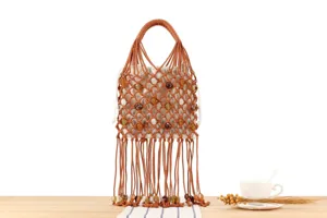 Close-up detail of the stylish brown woven handbag featuring beads and fringe design.