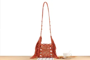Handmade macrame woven crossbody shoulder bag detail, textured fringe design with inner lining.