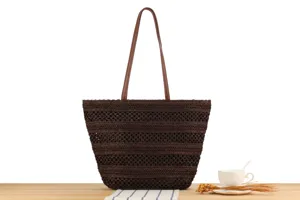Detailed view of dark brown woven tote bag on wooden table with elegant teacup decor.