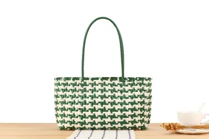 Green and white woven plastic tote bag detail, stylish beach shoulder bag for women daily use.