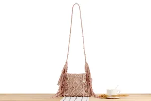 Close-up view of the handmade pink woven crossbody bag featuring delicate fringe and net details.