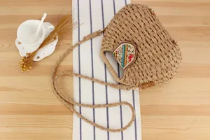 Detailansicht der handgemachten Stroh Umhängetasche mit bunter Perlenklappe und Flechtgurt.
