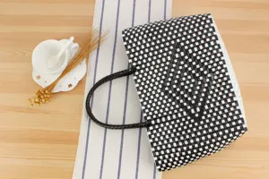 Borsa tote in plastica intrecciata nera e bianca da donna, elegante shopper da spiaggia.