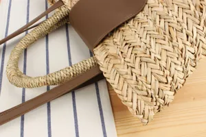 Dettaglio borsa di paglia intrecciata a mano in erba naturale e PU, borsa da spiaggia casual donna.