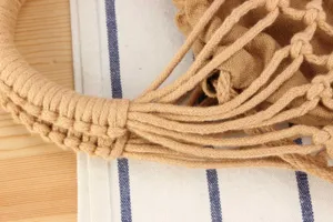 Beige woven handbag detail shot, stylish hollow mesh design for casual summer daily wear.