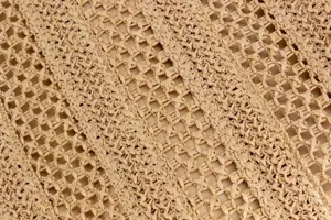 Detailed close-up view of woven straw bag texture, casual summer beach handbag material.
