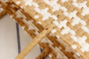Close-up detail of stylish woven plastic beach tote bag with chic tan and white check pattern.
